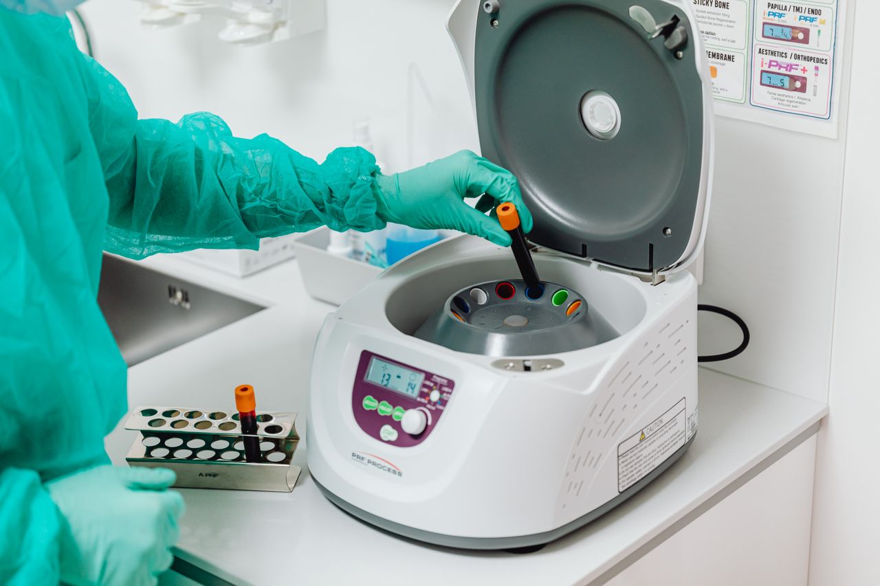 gallery-06 A healthcare professional operates a centrifuge machine in a laboratory, ensuring sterile medical procedures.