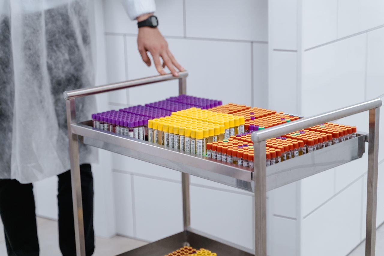 gallery-04 Organized laboratory test samples in colorful capped vials on a steel cart.